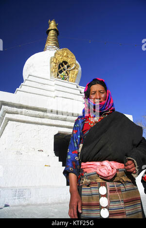 Tibetan woman standing next to a chorten in Lhasa, Tibet Stock Photo