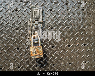 Old rusty iron padlock on metal door as symbol of safety security protection, secure data idea or rusted lock rust as unprotected, unsecured concept. Stock Photo