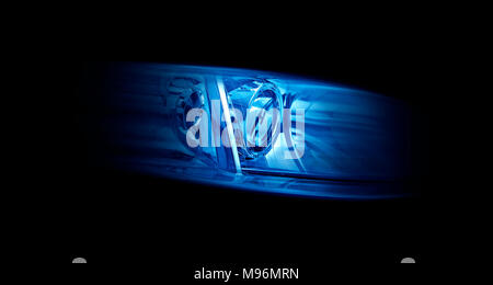 Modern automotive headlight on a black background shine blue light. Stock Photo