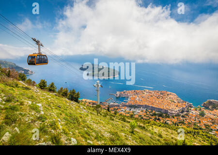 Aerial panoramic view of the old town of Dubrovnik with famous Cable Car on Srd mountain on a sunny day with blue sky and clouds in summer, Croatia Stock Photo