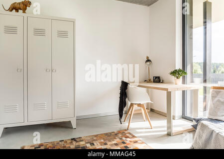 White home interior with metal wardrobe, desk and chair Stock Photo