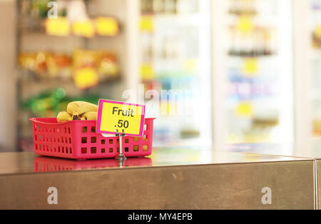 school canteen tuck shop cafeteria selling healthy fruit food options for students. bananas in a red tray on stainless steel bench in foreground Stock Photo