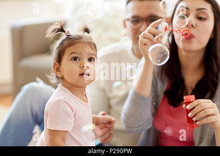 family with soap bubbles playing at home Stock Photo