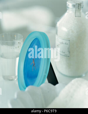 Close-up of circular turquoise glass  frame with jar of bath salts Stock Photo