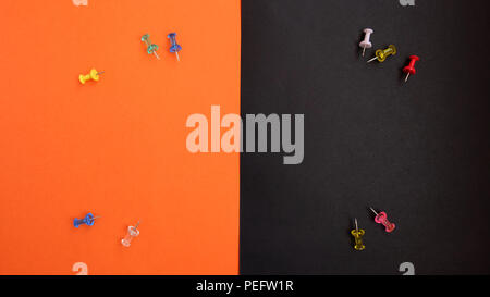 Colorful push pins with orange and black background Stock Photo