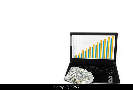 Laptop or notebook with widespread of cash dollar money isolated on white background with bar chart graph on display. Stock Photo