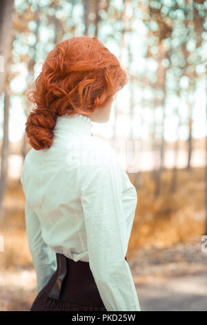 Victorian woman standing in forest Stock Photo