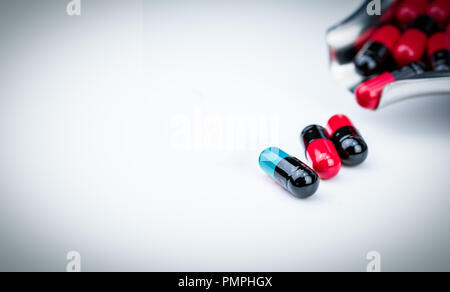 Selective focus blue-green capsule pill and drug tray with red-black capsule. Global healthcare. Antibiotics drug resistance. Antimicrobial capsule pi Stock Photo