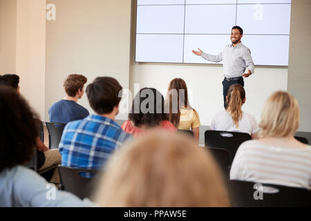 Teacher Giving Presentation To High School Class In Front Of Screen Stock Photo