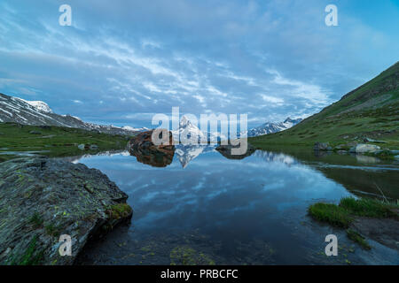 Blue hour shot of the Matterhorn (Monte Cervino, Mont Cervin) pyramid and Stellisee lake. Early morning view of majestic mountain landscape. Valais Al Stock Photo