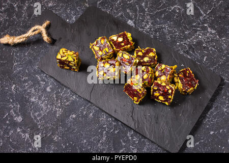 Turkish delight with pistachio nuts on dark stone background. Stock Photo