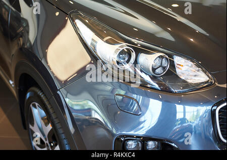 automobile headlights of new modern car in showroom. closeup Stock Photo