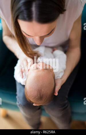 Overhead View Of Mother Cuddling Newborn Baby Son At Home Stock Photo