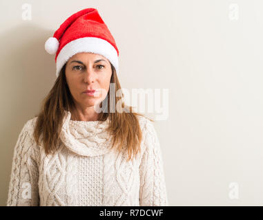 Middle age woman wearing christmas santa claus hat with a confident expression on smart face thinking serious Stock Photo