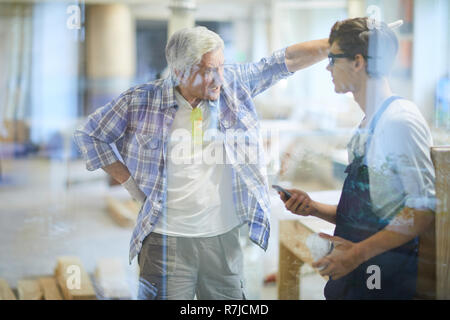 Furious carpenter foreman yelling at lazy worker Stock Photo