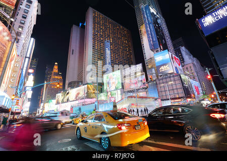 NEW YORK, USA - APRIL 12: The architecture of the famous Times Square in New York city, USA with its neon lights and panels at night and a lot of tour Stock Photo