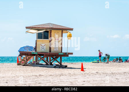 Hollywood, USA - May 6, 2018: Lifeguard building along ocean coast in Miami Florida during day with people and umbrella on sand Stock Photo