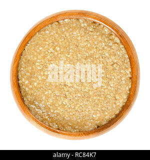 Homemade tahini, sesame paste, in wooden bowl. Brown condiment made of ground hulled sesame seeds. Dip or ingredient in hummus, baba ghanoush, halva. Stock Photo