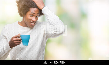 Afro american man drinking cup of coffee over isolated background stressed with hand on head, shocked with shame and surprise face, angry and frustrat Stock Photo