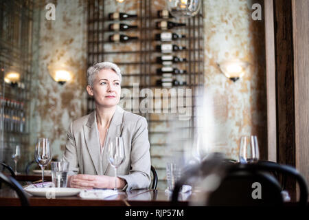 Successful businesswoman thinking in a restaurant Stock Photo