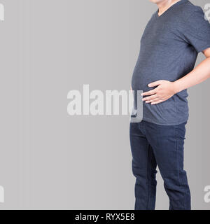 fat man with belly fat excess hand on abdomen isolated on grey backgroud Stock Photo