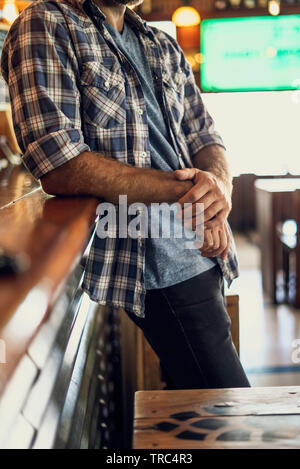 Man leaning against bar counter Stock Photo