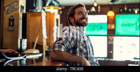 Man leaning against bar counter Stock Photo