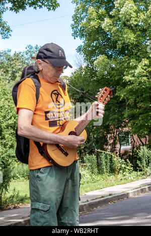 OTTAWA, ONTARIO, CANADA - August 23, 2019: An activist stands playing a guitalele during a protest outside the Embassy of Brazil. Stock Photo