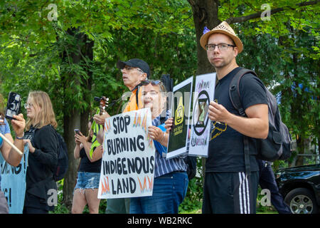 OTTAWA, ONTARIO, CANADA - August 23, 2019: Activists outside the Embassy of Brazil hold signs protesting the current burning of the Amazon rainforest. Stock Photo