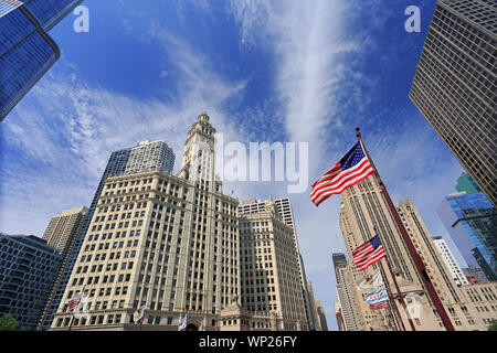 Wrigley Building and Tribune Tower on Michigan Avenue with Illinois flag on the foreground in Chicago, USA Stock Photo