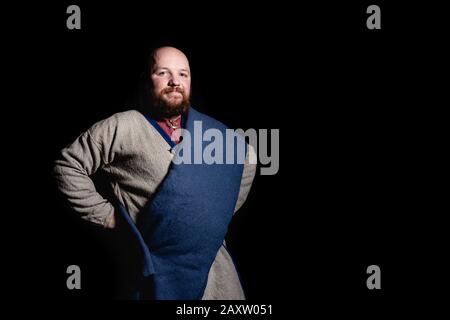 Übergewichtiger bärtiger Mann im Bild eines mittelalterlichen Kaufmanns Stockfoto