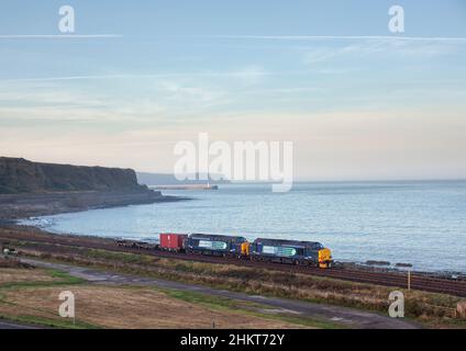 2 Direct Rail Services der Baureihe 37 Lokomotiven 37259 + 37611 Passieren Sie Parton auf der malerischen Küstenlinie Cumbrias mit einem Container für nukleare Abfälle Stockfoto