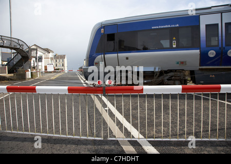 NIR Zug vorbei Level Crossing Barrieren nach unten geschlossenen Castlerock Railway station Nordirland Vereinigtes Königreich Aktion Bewegungsunschärfe Stockfoto