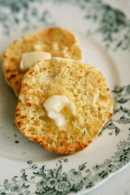 two halves of an english muffin with butter on them