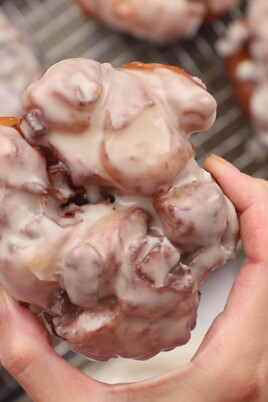 woman's hand holding iced Apple Fritters