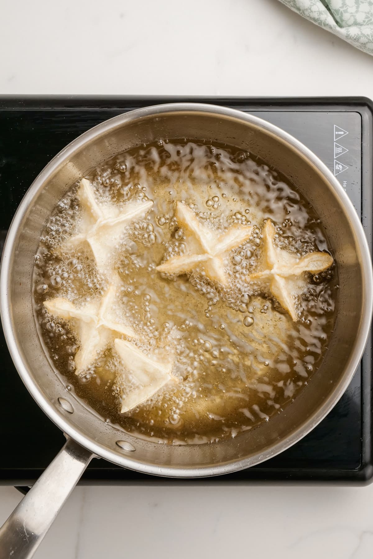 uncooked crab Rangoons in fryer