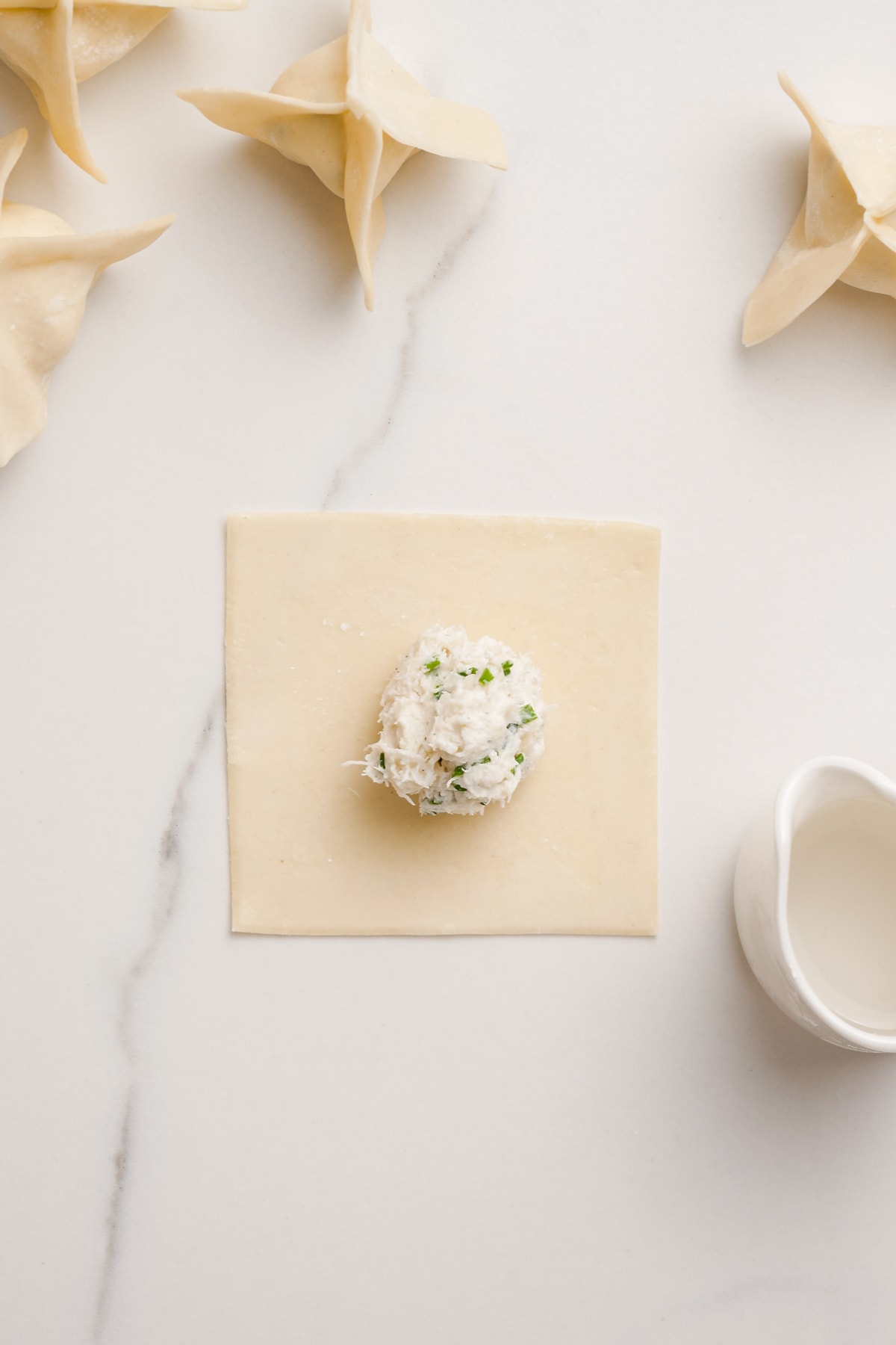 scoop of crab filling on the center of a wonton paper