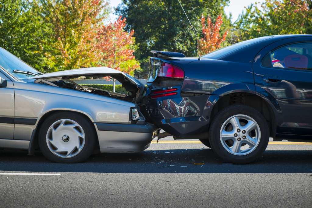 two cars involved in a car accident at a side of a road