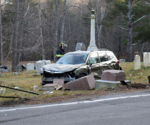 A firefighter investigates a 2020 Subaru Forester in the Glidden Cemetery on River Road in Newcastle following a collision on Dec. 13. (Nate Poole photo)