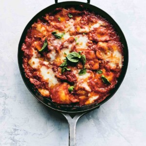 A metal skillet filled with easy skillet lasagna and garnished with basil leaves.