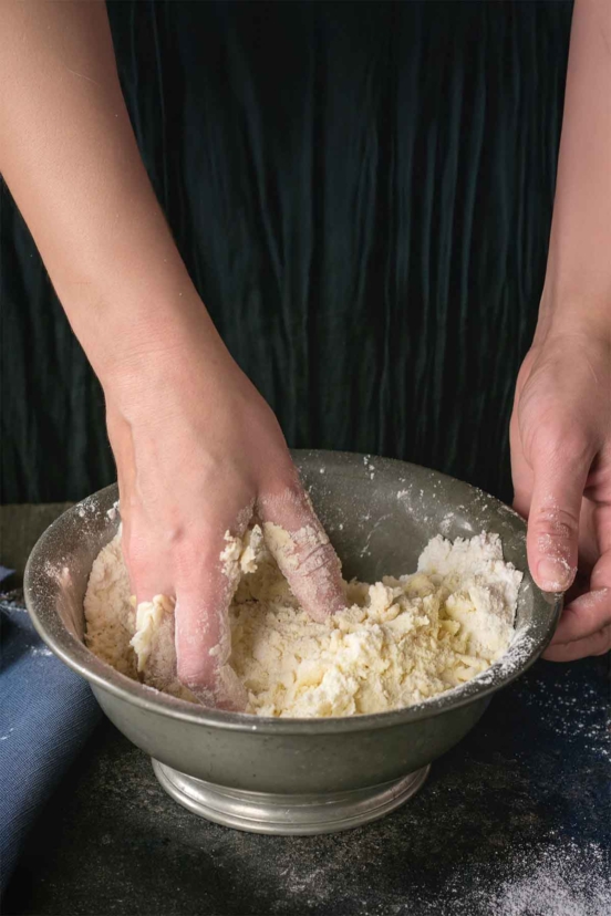 Shortcut pie crust being mixed together by hand in a bowl.