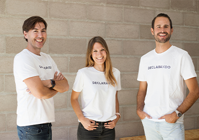 Founding team members of Declarando are posing against a wall with matching shirts.