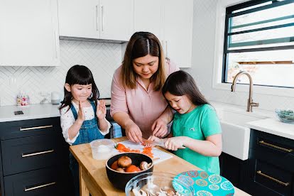 To explore new things offline, a mother and her two young daughters chop a red pepper.