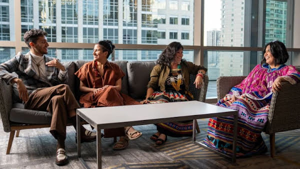 Four people sitting around a table talking at a Natives in Philanthropy event.