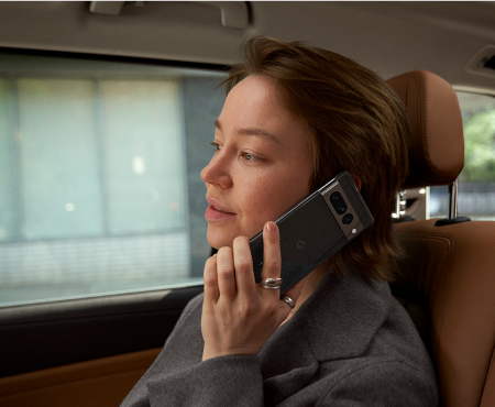 A woman on the train using her Pixel phone to make a call.