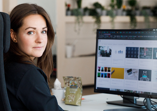 a woman operating a computer looking at the camera