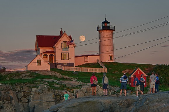 People watch the nearly 'super' Moon rise on August 9, 2014 near a lighthouse.  Credit and copyright:  Will Nourse. 