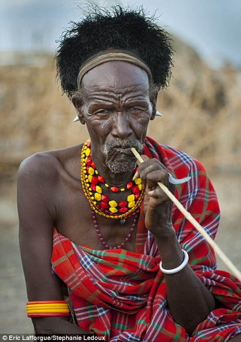 Toothbrush: A man uses an esekon stick to clean his teeth