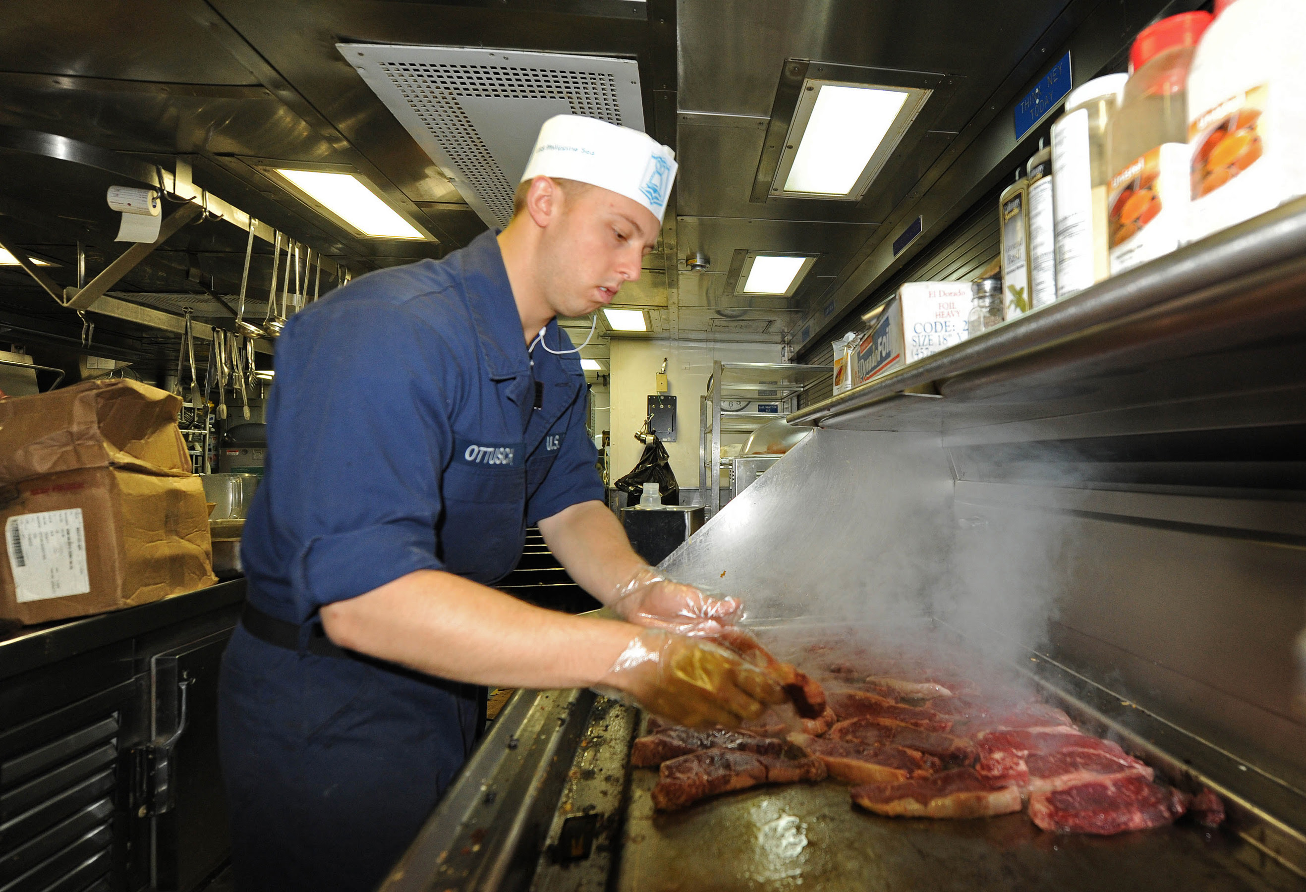 US_Navy_111020 N RB564 009_Culinary_Specialist_Seaman_Alex_Ottusch_cooks_steak_on_the_grill_for