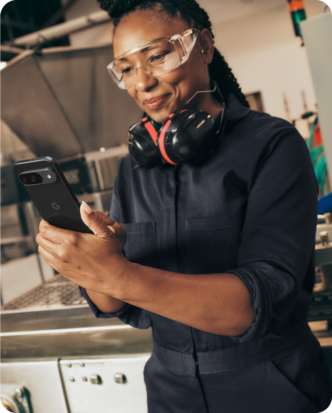 A woman working on her Google Pixel 9 phone in a warehouse.